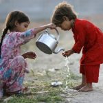Internally displaced girls, who fled a military offensive in the Swat valley region, help each other wash hands at the UNHCR (United Nations High Commission for Refugees) Sheik Shahzad camp in Mardan district, about 160 km (99 miles) northwest of Pakistan's capital Islamabad June 18, 2009.   REUTERS/Akhtar Soomro   (PAKISTAN CONFLICT POLITICS SOCIETY IMAGES OF THE DAY)