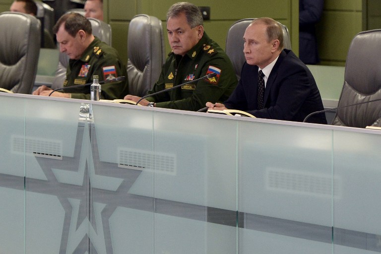 Russian President Vladimir Putin (R), accompanied by Defence Minister Sergei Shoigu (C), meets with top military officials at the National Defence Control Centre of the Russian Federation in Moscow on November 17, 2015. President Vladimir Putin on November 17 ordered the Russian navy in the Mediterranean to establish contact with its French counterparts and work together "as allies" in a campaign against the Islamic State group in Syria. AFP PHOTO / SPUTNIK / ALEXEI NIKOLSKY / AFP / SPUTNIK / ALEXEI NIKOLSKY