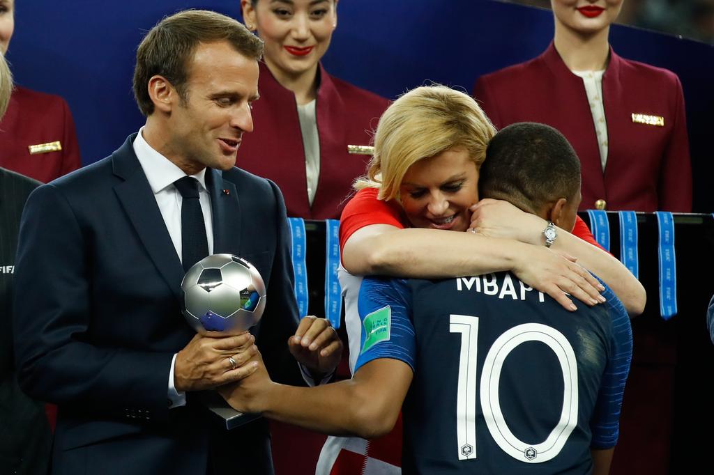 France's forward Kylian Mbappe receives the silver ball for best young player from French President Emmanuel Macron and Croatian President Kolinda Grabar-Kitarovic during the medals ceremony after the Russia 2018 World Cup final football match between France and Croatia at the Luzhniki Stadium in Moscow on July 15, 2018. / AFP PHOTO / Odd ANDERSEN / RESTRICTED TO EDITORIAL USE - NO MOBILE PUSH ALERTS/DOWNLOADS